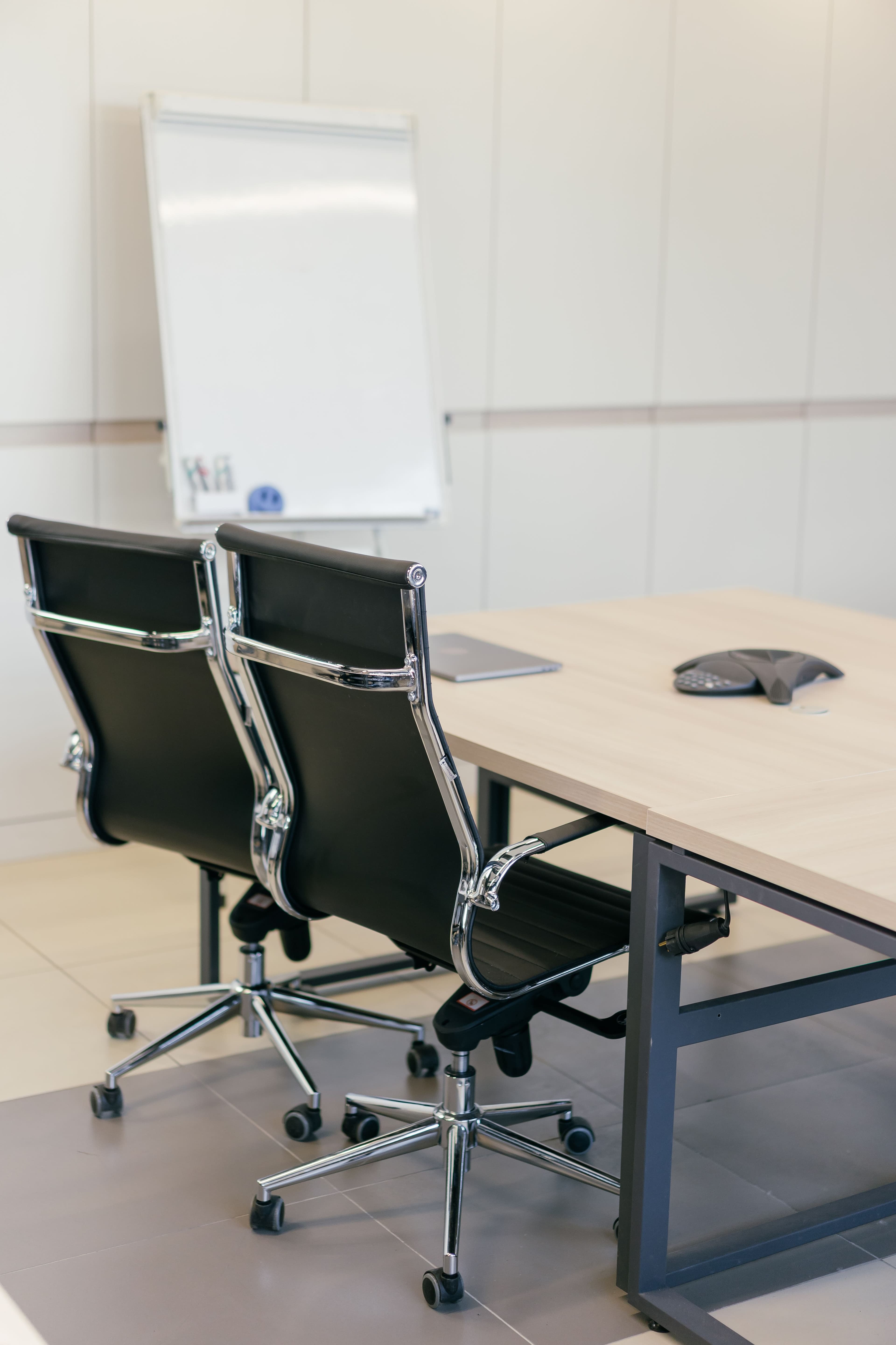 Sala de reunião com cadeiras executivas e quadro branco